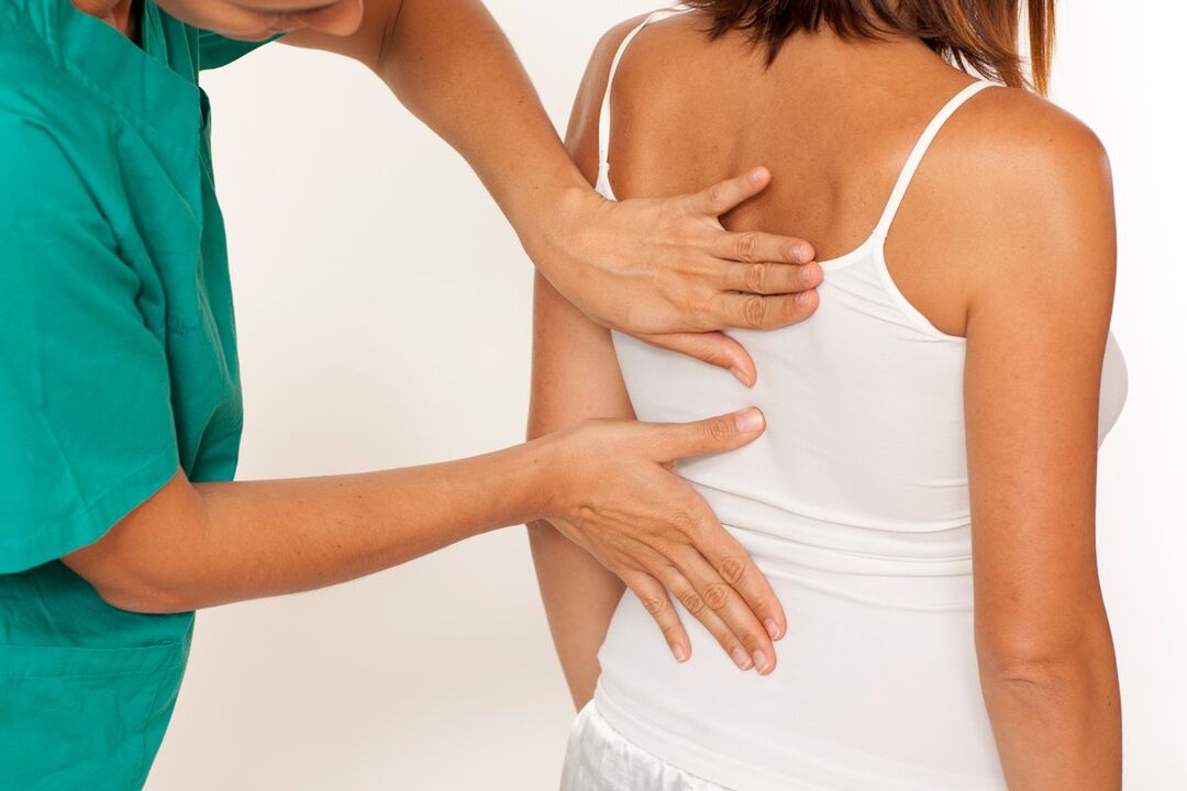 der Arzt untersucht den Rücken auf Schmerzen im Bereich der Schulterblätter